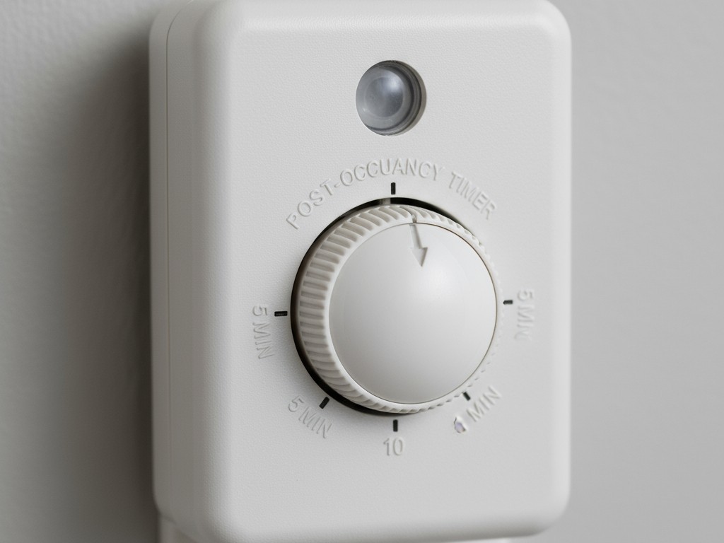 Pengatur Waktu Pasca-Keberadaan pada Steker Sensor Gerak Tampilan dekat steker sensor gerak yang menunjukkan sebuah tombol kecil untuk mengatur waktu tunda, dengan opsi seperti 5, 10, dan 15 menit.