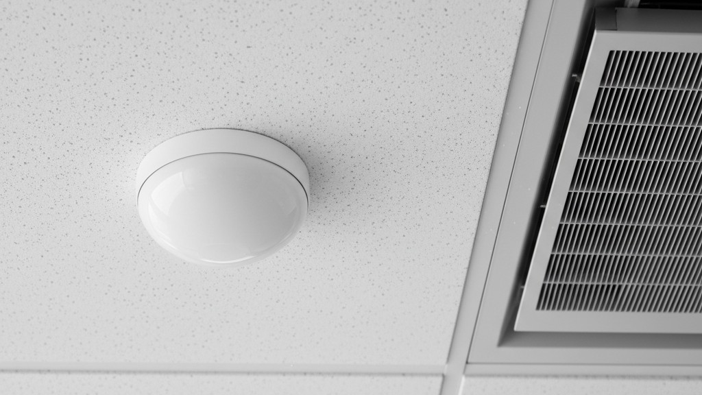 Sensor placement near HVAC vent A close-up of a round white ceiling motion sensor mounted directly next to a square metal HVAC air vent.